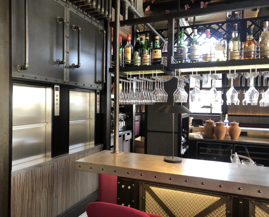 Kleinlastenaufzug mit zwei Edelstahltüren im Servicebereich einer Bar