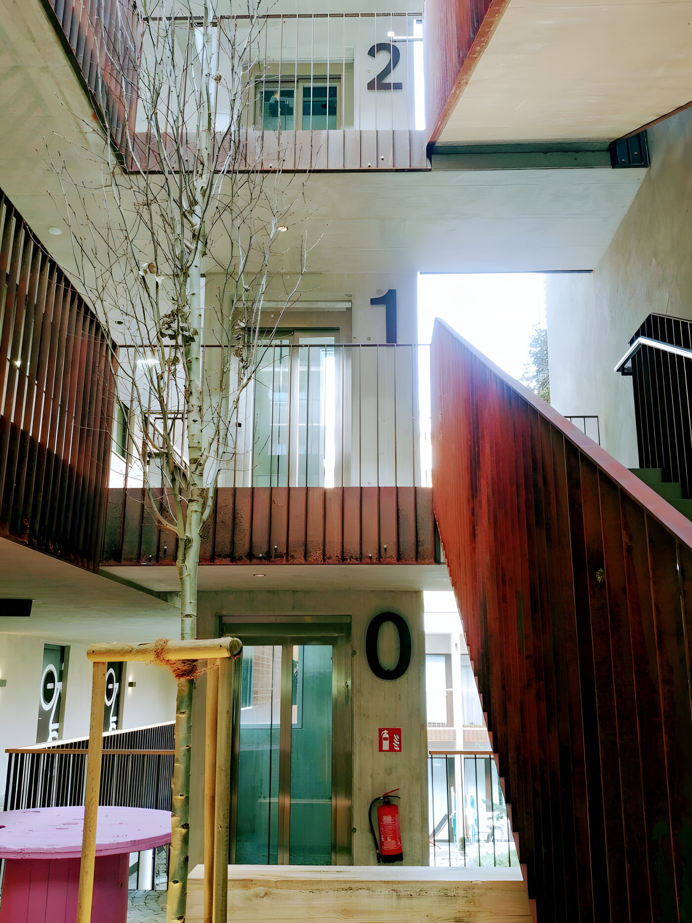 Aufzug in einem modernen Gebäude-Atrium mit Corten-Stahl-Treppe