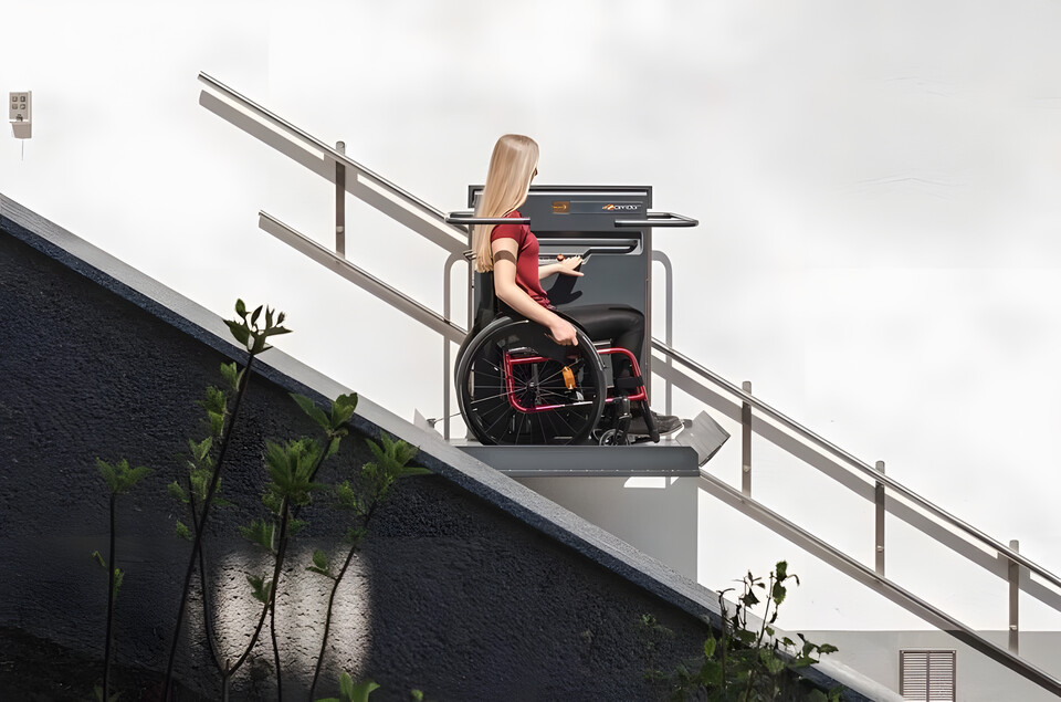 Treppenlift im Außenbereich mit Rollstuhlfahrerin