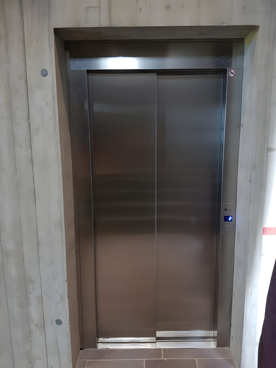 Edelstahltür in einer Sichtbetonwand